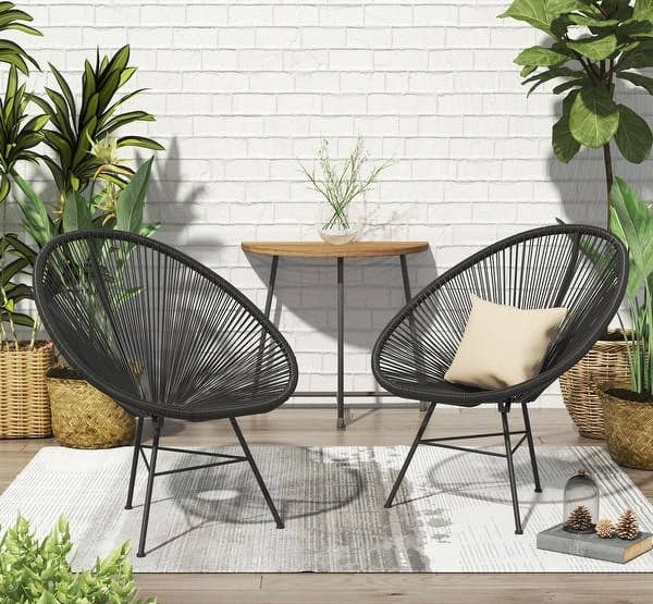 a pair of circular wicker chairs in black 
