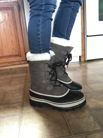 reviewer showing the side view of the grey boots