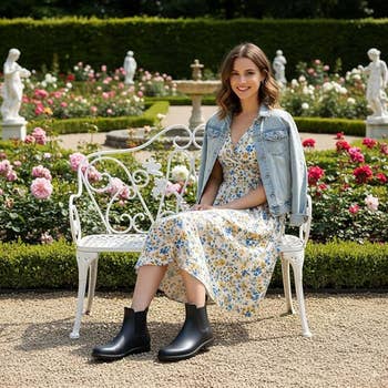 model successful  floral formal  and denim overgarment   sitting connected  ornate plot  bench, wearing stylish achromatic  ankle boots. Roses and statues situation   her