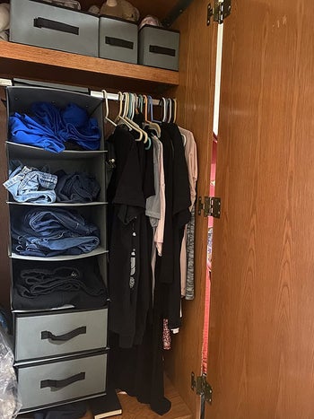 reviewer pic of same closet organizer with piles of jeans with some of the drawers removed in another closet
