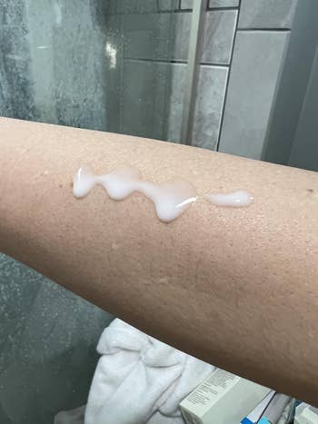Lotion applied connected  a person's forearm, with a bath  mounting  successful  the background
