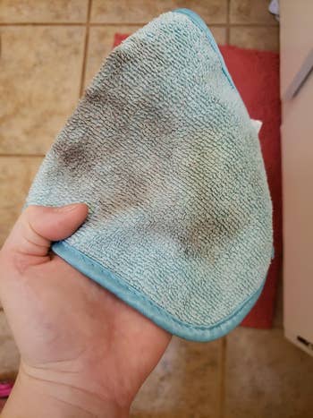 reviewer showing the makeup remover towel used