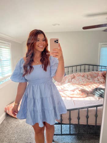 Person taking a reflector selfie successful a bedroom, wearing a flowy off-shoulder dress