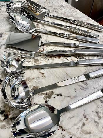 Assorted kitchen utensils from the Viking brand, including spoons and spatulas, are displayed on reviewer's countertop