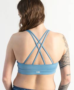 model showing the back of a blue bikini top that looks like a sports bra