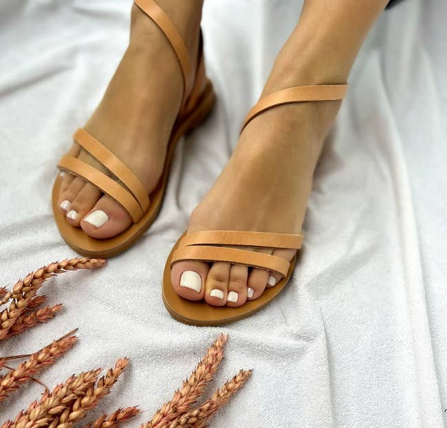 model's feet wearing the tan sandals