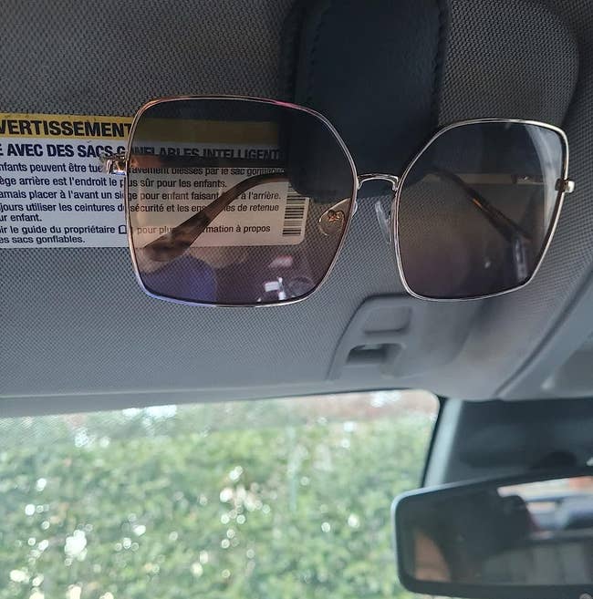 A reviewer's sunglasses in magnetic clip in sun visor
