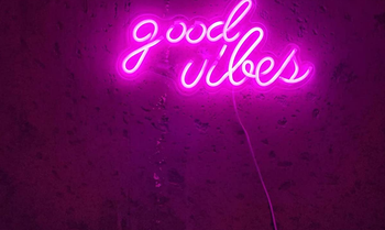 A close up of the neon sign glowing bright pink