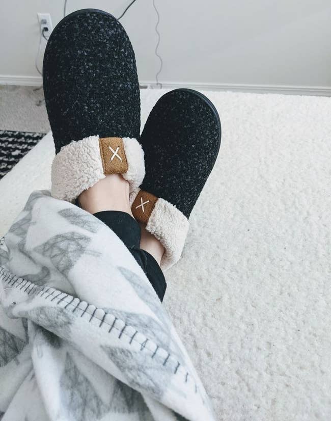 reviewer wearing the sherpa-lined house slippers in black