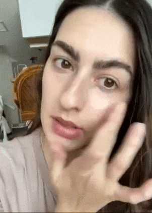 Person applying skincare merchandise  to face, mildly  massaging it successful  circular motions. Ideal for a buying  nonfiction  connected  quality   and skincare products