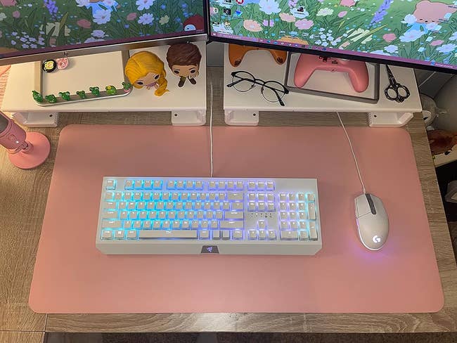 reviewer's pink desk pad with their keyboard and mouse on it 