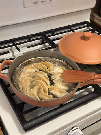 Dumplings steaming successful  a modern   cookware  connected  a stovetop, accompanied by a matching lid, cleanable   for location  cooking enthusiasts
