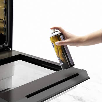 Model spraying product on interior of oven