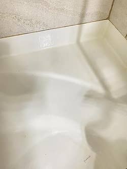 Clean, empty bathtub with smooth surface and tiled walls in a modern bathroom setting