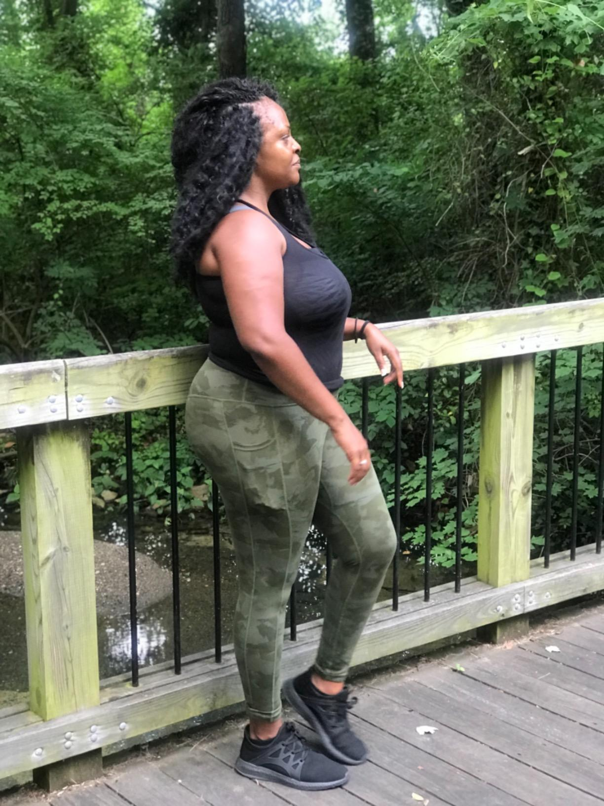 reviewer wearing the camo leggings connected  a bridge