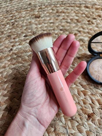 Hand holding Doucce makeup brush