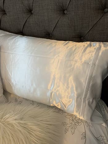 the white satin pillowcase on a reviewer's bed