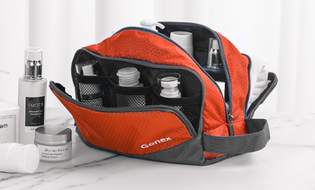 lifestyle image of orange toiletry bag, showing mesh compartments inside