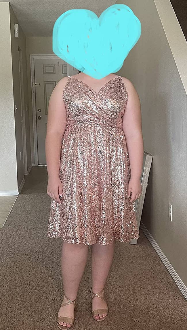 Reviewer wearing glittery sleeveless rose gold dress