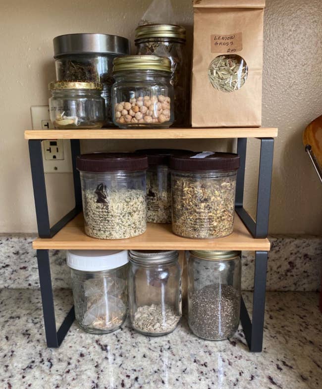 a reviewer using the shelf organizer on their countertop 