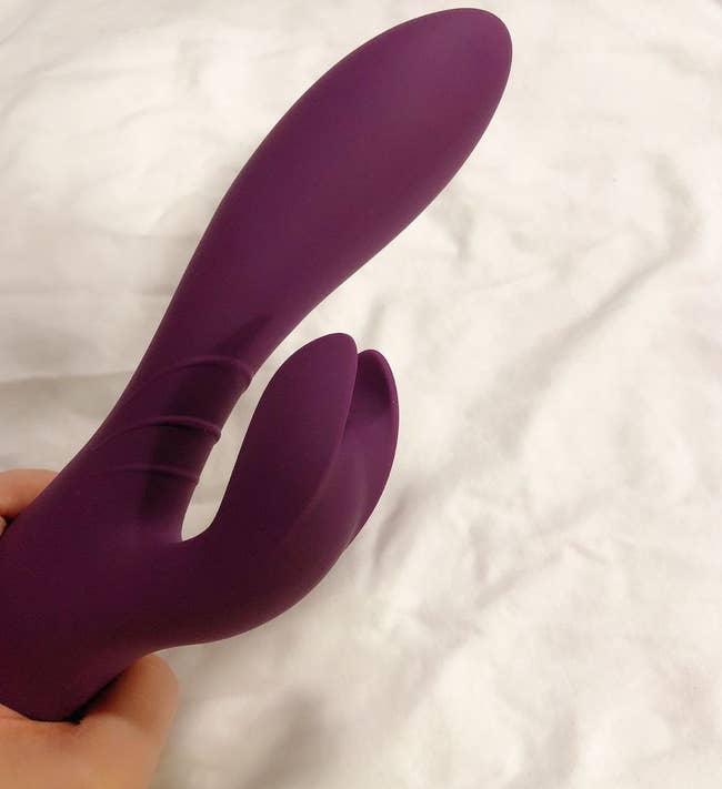 Reviewer holding purple rabbit vibrator