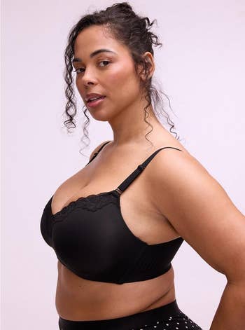 Person modeling a lace-trimmed, supportive bra