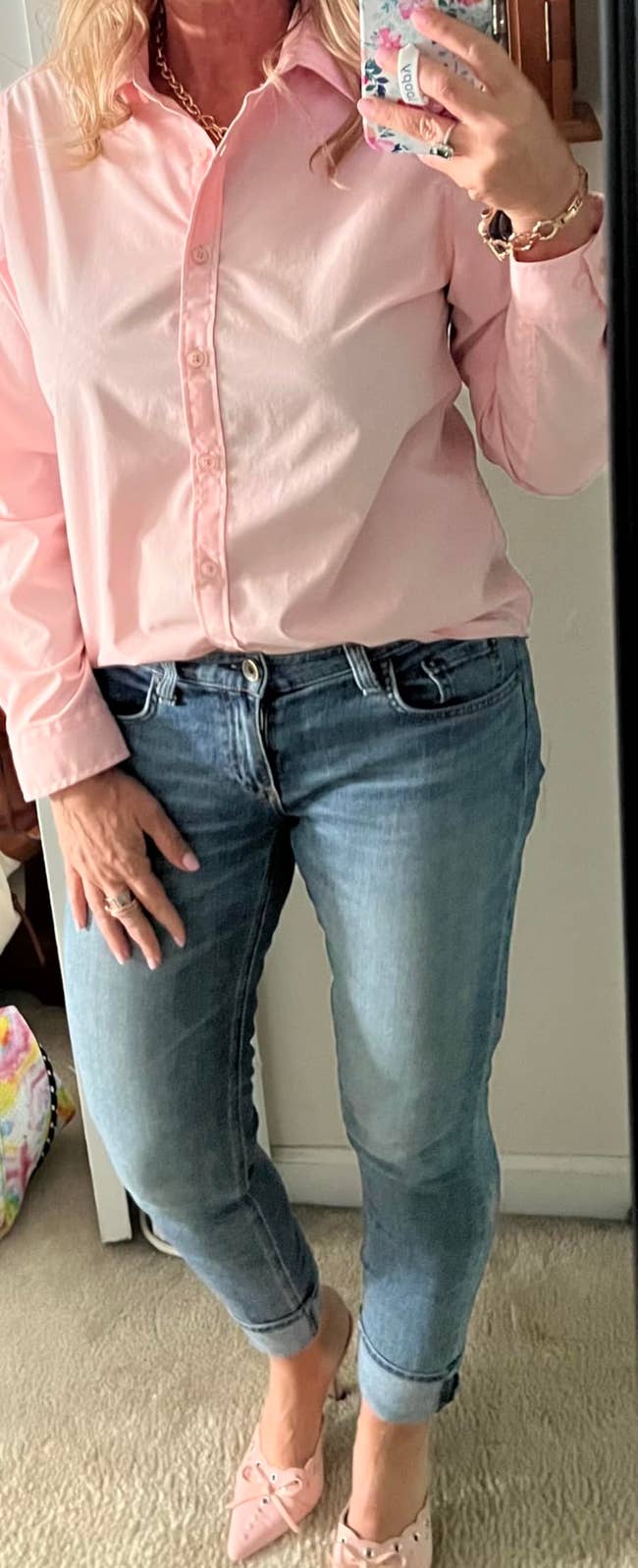 Person taking a reflector selfie, wearing a casual button-up shirt, jeans, and slip-on shoes, showcasing a laid-back benignant for mundane wear