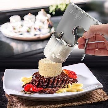A model using the scoop to place ice cream on top of a chocolate cake