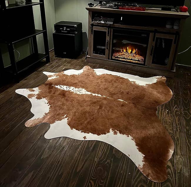 reviewer image of the brown cowhide rug in a living room