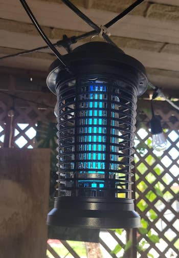 a reviewer photo of the bug zapper lantern hanging outside 