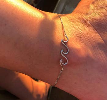 Reviewer wearing the silver ankle bracelet in the sun