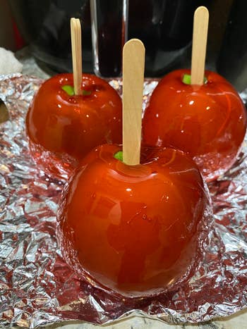 Three glossy candy apples with woody sticks connected crinkled foil, cleanable for a saccharine dainty oregon acquisition idea