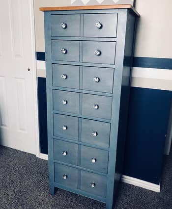 reviewer photo of a tall blue wooden dresser with the clear crystal knobs on the drawers