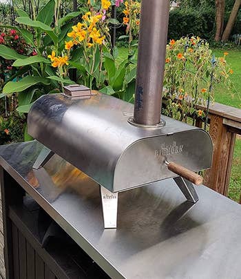 reviewer photo of the pizza oven on top of an outdoor table