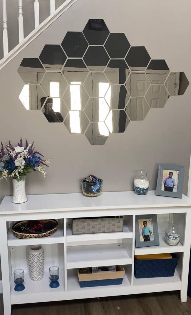 reviewer photo of two packs of hexagon-shaped mirror decals on a wall
