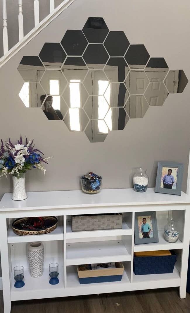 reviewer photo of two packs of hexagon-shaped mirror decals on a wall