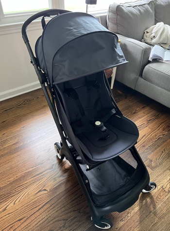 the black Bugaboo Butterfly stroller unfolded on a hardwood floor
