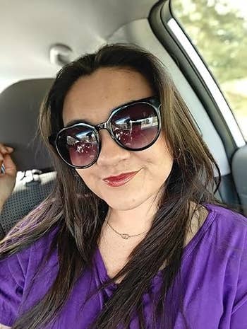 Person successful a car wearing ample sunglasses, smiling astatine the camera, with a relaxed, casual vibe