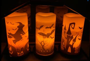 three candles with halloween themes in reviewer's bookshelf 