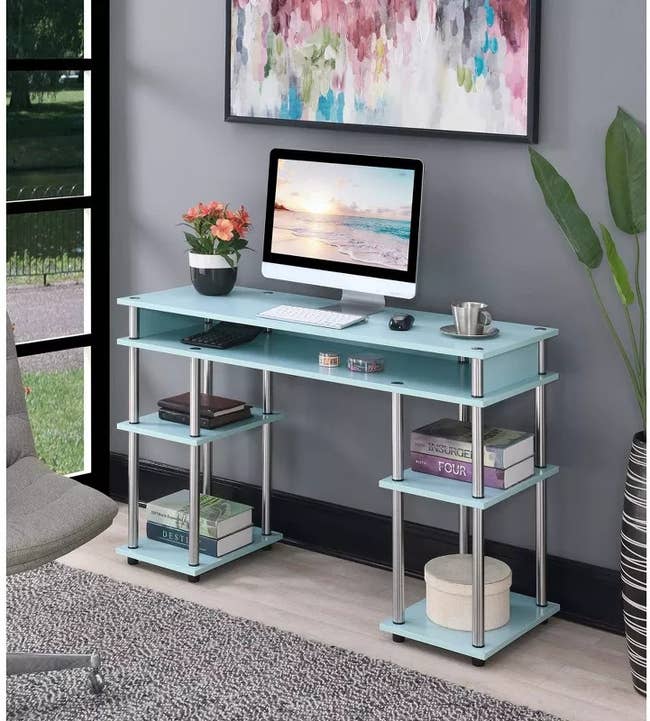 the light blue desk with shelving on each side and an open drawer in the middle