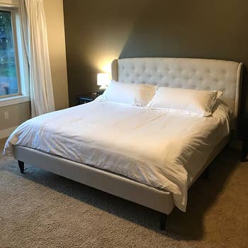 reviewer photo of tufted beige linen bed frame in bedroom