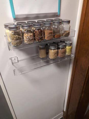Kitchen spice rack mounted on a wall, holding various jars filled with herbs and spices for organized storage