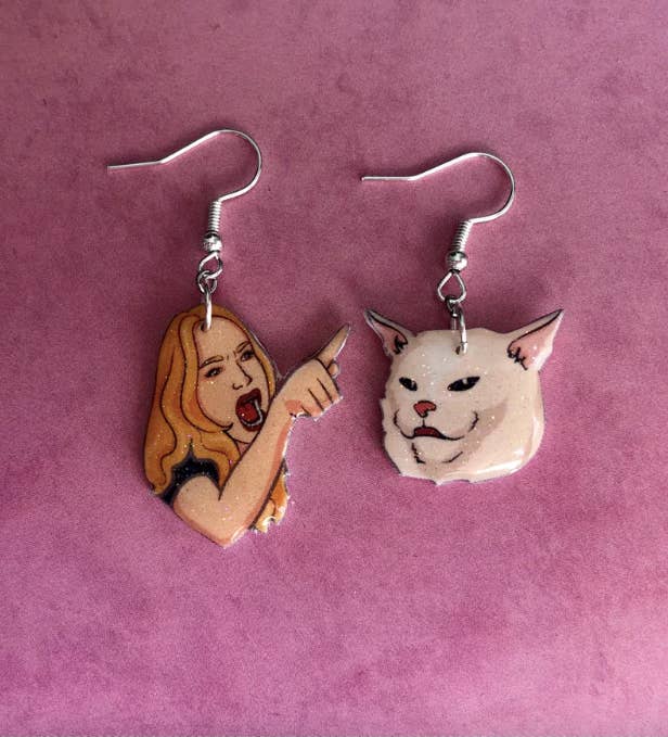 drop earrings one with charm of woman yelling and pointing and the other with charm of grumpy white cat
