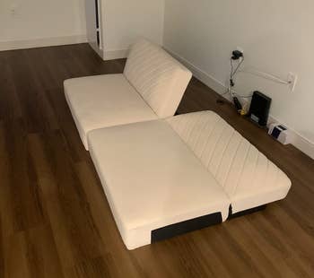 reviewer photo of their white futon without legs with have of it reclined and the other half upright