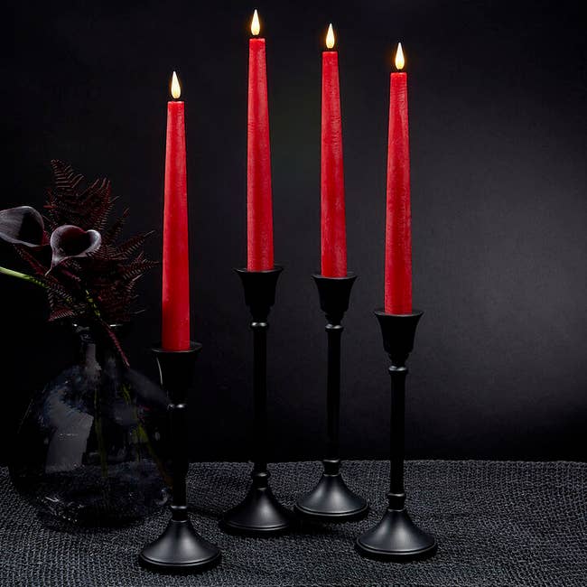four red taper candles with imitation flames