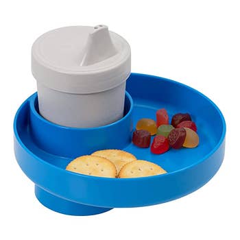 A closeup of the tray holding a sippy cup, crackers, and fruit snacks