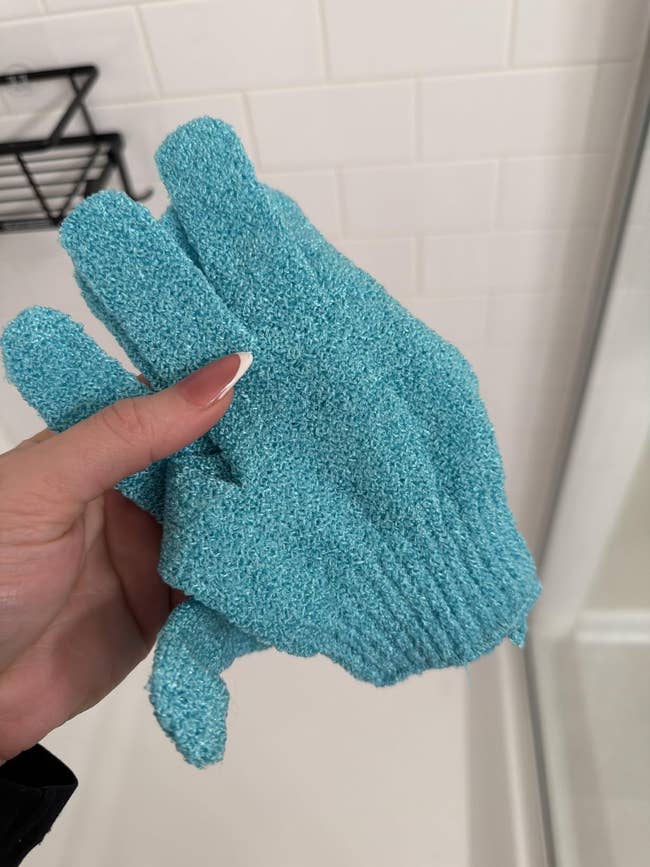Textured exfoliating mitt successful a person's hand