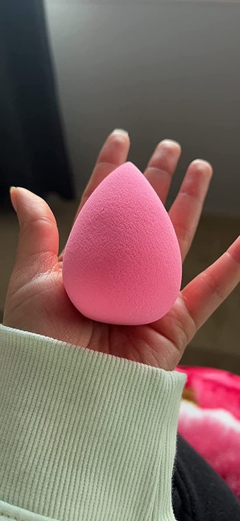 reviewer holding pink beauty sponge
