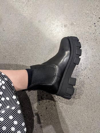 reviewer showing a side view of the black boots