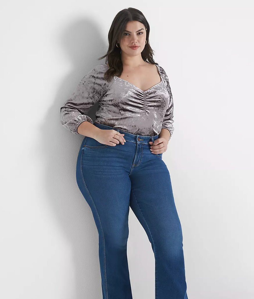 Model is wearing a silver velvet sweetheart top and denim jeans